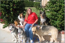Photo of Patty Thurner sitting with five dogs